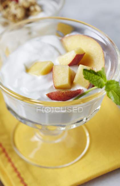 Closeup view of yogurt with nectarines in bowl — Stock Photo