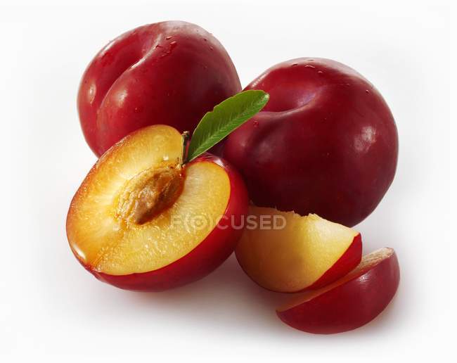Ameixas vermelhas maduras com fatias — Fotografia de Stock
