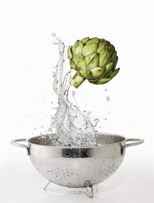 Artichoke with splash of water — Stock Photo