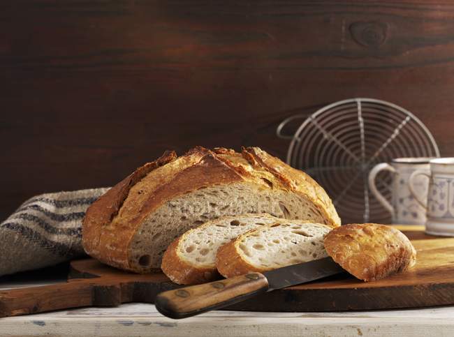Partly sliced mixed-wheat loaf — Stock Photo