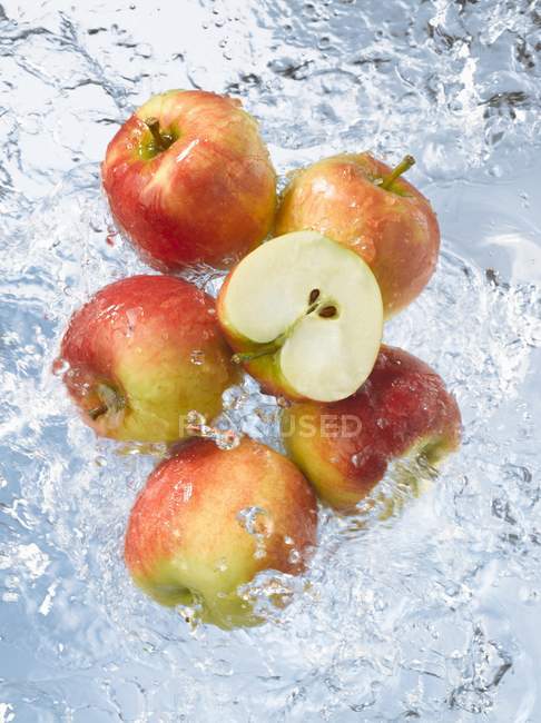 Äpfel mit der Hälfte im Wasser — Stockfoto