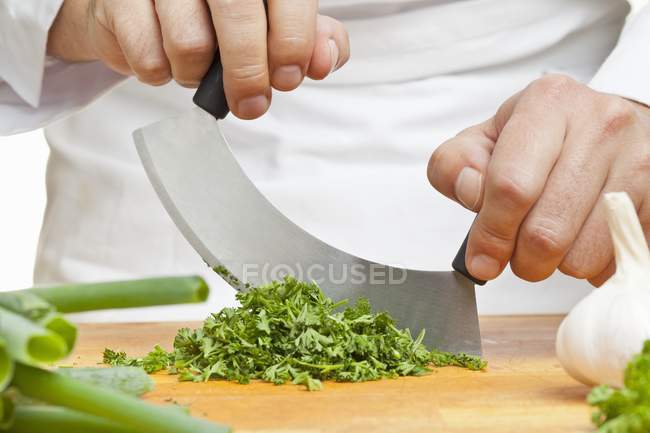 Homem cortando salsa encaracolado — Fotografia de Stock
