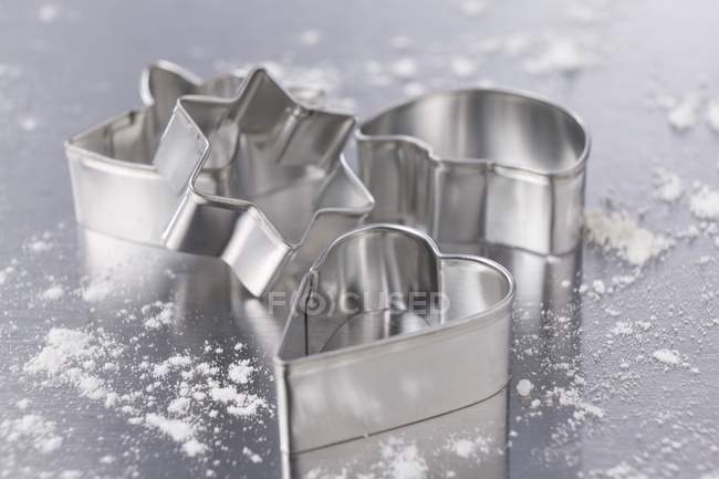 Closeup view of assorted cookie cutters with flour — Stock Photo