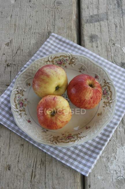Яблоки на деревенской плите — стоковое фото