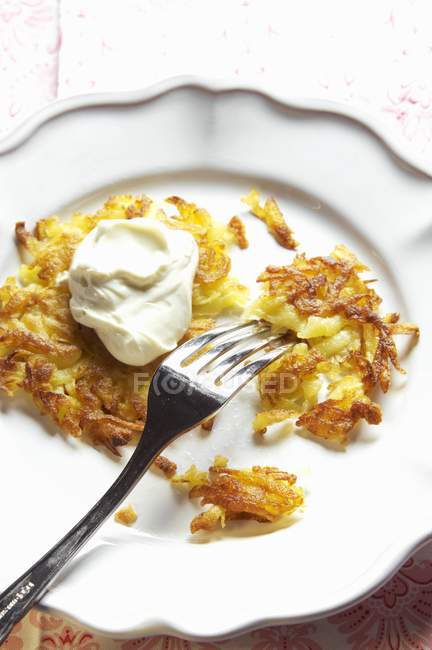 Potato rosti with sour cream — Stock Photo