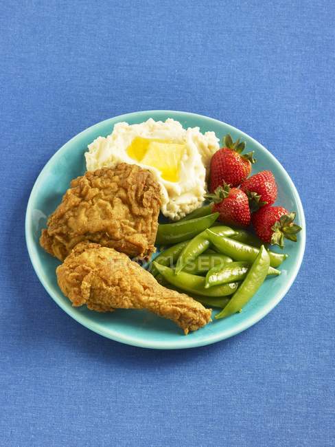 Fried chicken with mashed potatoes, strawberries and snap peas — Stock Photo