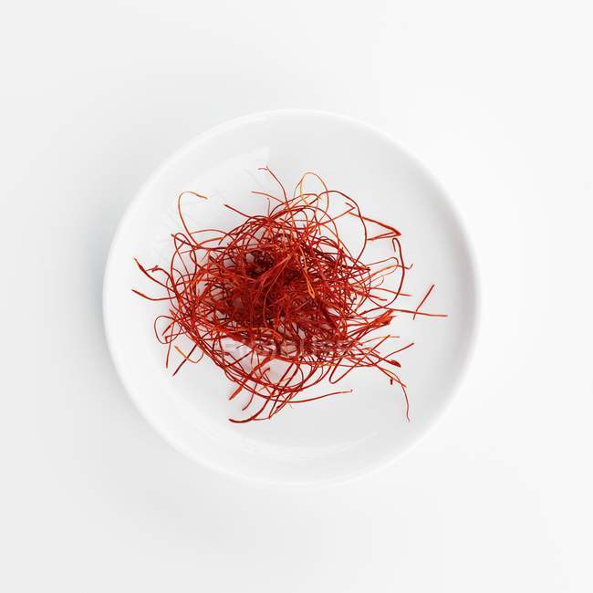 Top view of chilli threads on a white plate — Stock Photo
