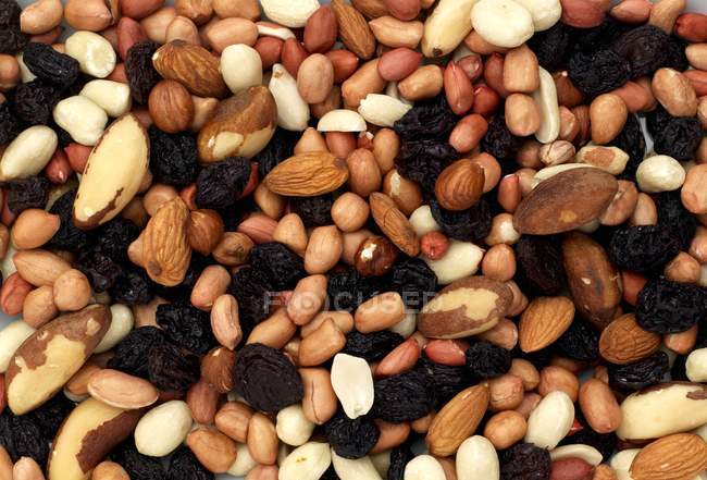 Mixed nuts and raisins in heap — Stock Photo