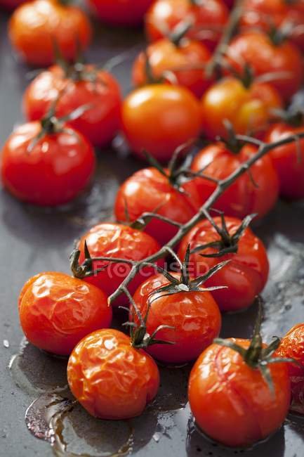 Oven-roasted cherry tomatoes on the baking tray — Stock Photo