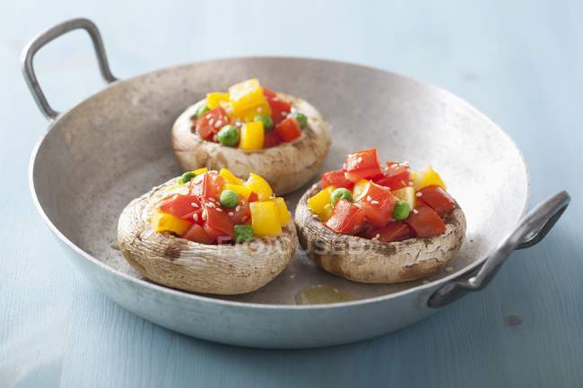 Mushrooms stuffed with tomatoes, yellow peppers and peas — Stock Photo