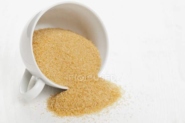 Azúcar de caña sin refinar en taza - foto de stock