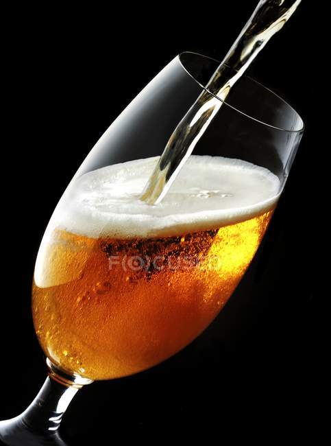 Verter cerveza en un vaso - foto de stock