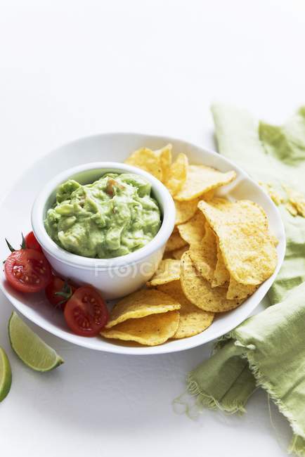 Guacamole dip with crisps and tomatoes — Stock Photo