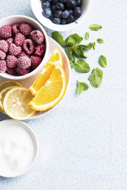 Frozen raspberries with oranges and lemons — Stock Photo