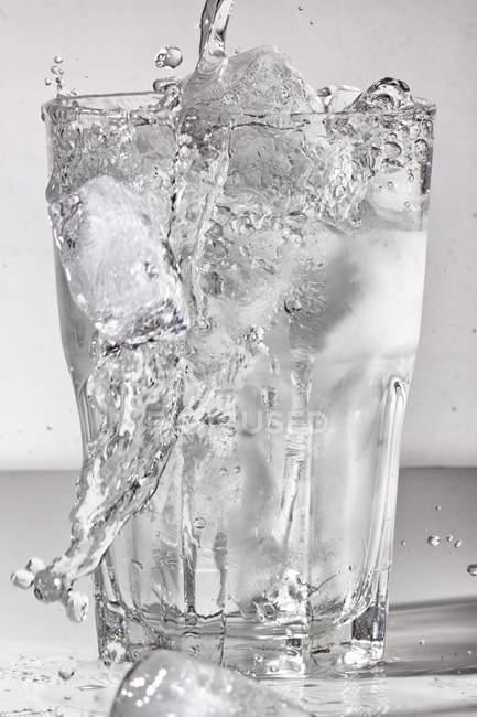 Water poured into glass of ice — Stock Photo