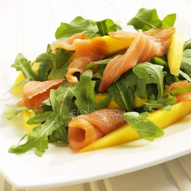 Arugula salad with salmon and mango — Stock Photo