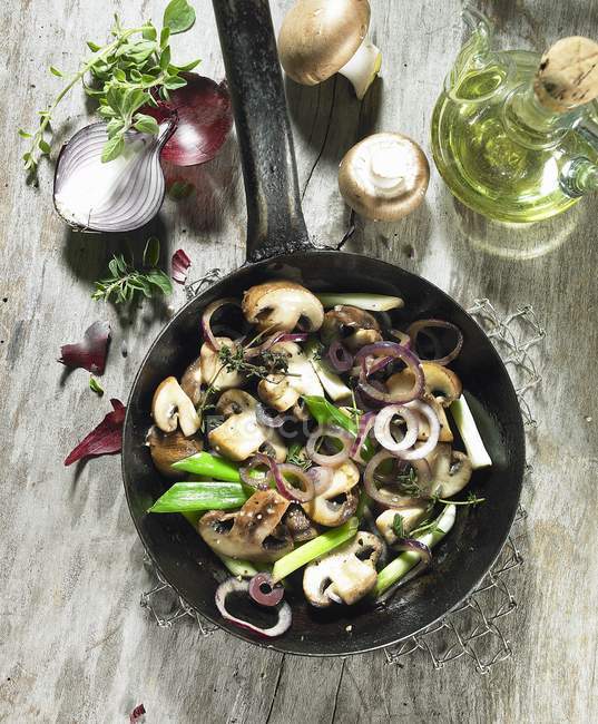 Fried mushrooms with red onions, spring onions, thyme marjoram and olive oil — Stock Photo