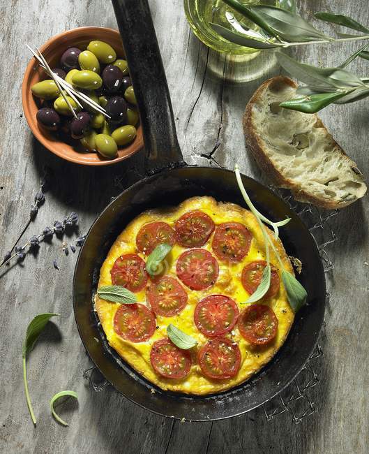 Omelete de tomate com azeitonas de salva, azeitonas pretas e verdes, azeite, azeitona, ciabatta de azeitona e lavanda — Fotografia de Stock