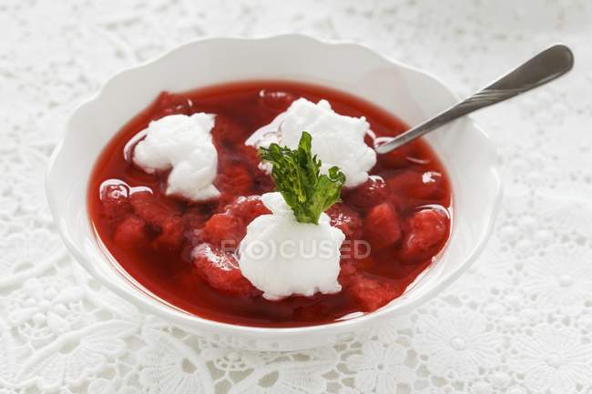 Cold strawberry soup with egg white dumplings  on white plate with spoon — Stock Photo