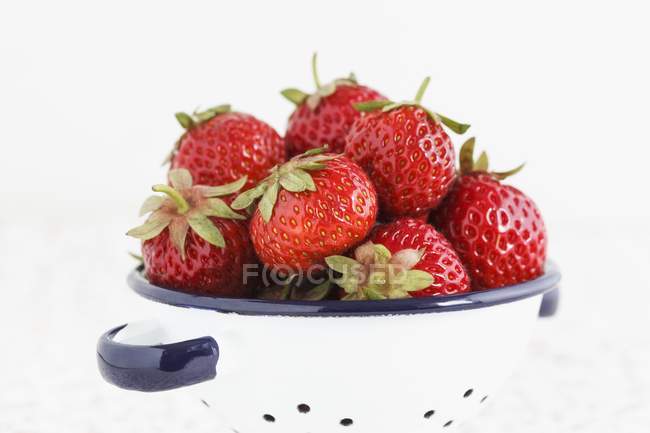 Strawberries in enamel colander — Stock Photo