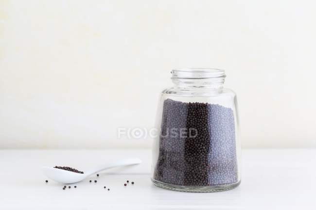 Semillas de mostaza negra en frasco - foto de stock