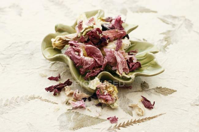 Vista close-up de flores de quiabo secas em um prato em forma de folha — Fotografia de Stock