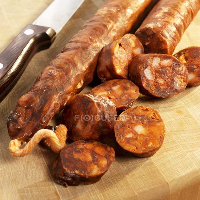 Vista da vicino della salsiccia spagnola Chorizo affettata con coltello sul tagliere — Foto stock