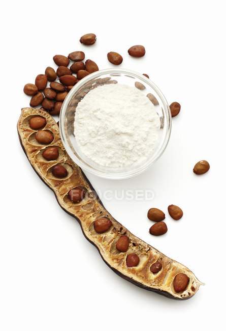 Carob bean flour and seeds — Stock Photo