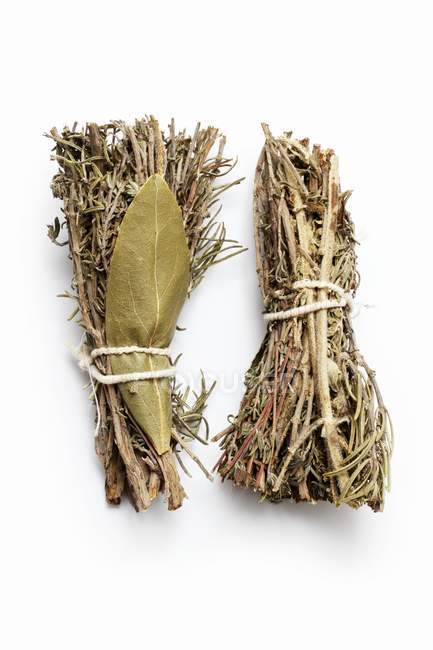 Dried bunches of herbs tied together  on white surface — Stock Photo