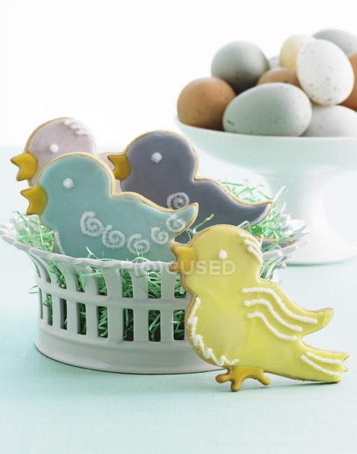 Vista de cerca de las galletas y huevos de Pascua decorados en forma de pájaro - foto de stock