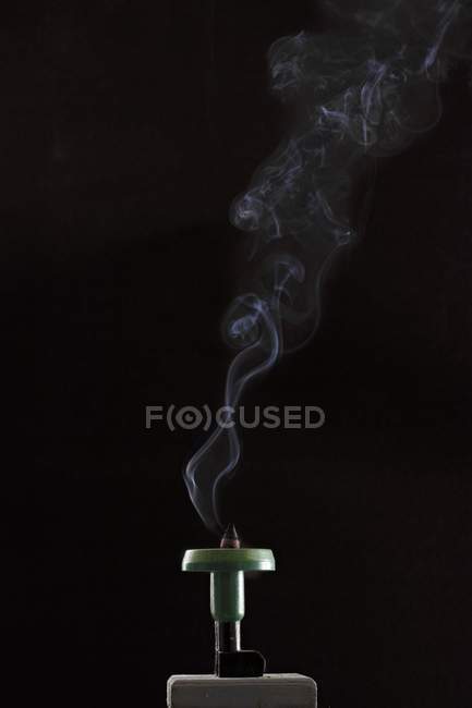 Vista close-up de um cone de incenso de fumar no fundo preto — Fotografia de Stock