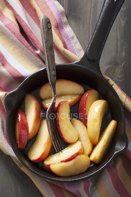 Вид сверху на карамельные ломтики яблока в сковороде — стоковое фото