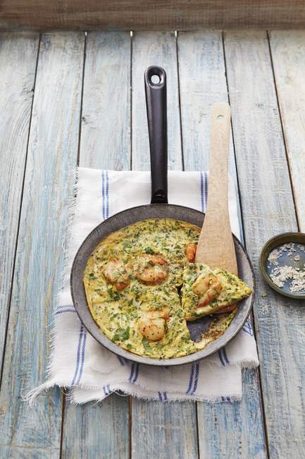 Elevated view of prawn omelette with herbs and spatula in pan — Stock Photo