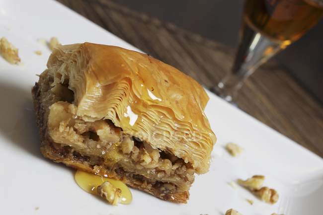 Closeup tilted view of Baklava piece on white surface — Stock Photo