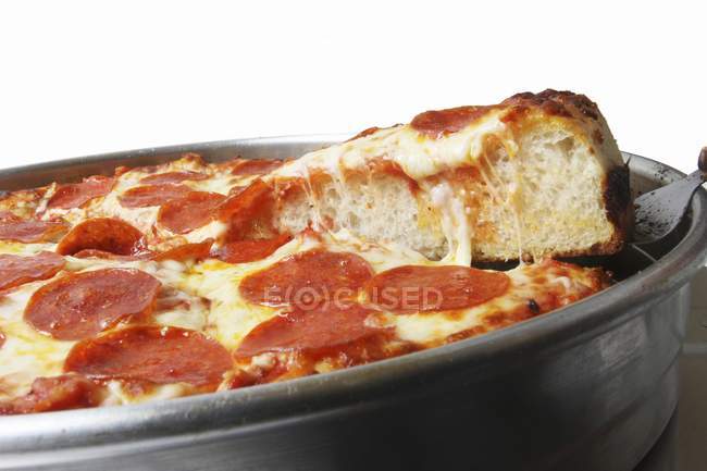 Pizza de Pepperoni con rebanada en espátula - foto de stock