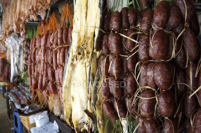 Крупный план камбоджийских колбас и других сушеных колбас на рынке — стоковое фото