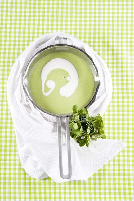 Pea soup with mint in saucepan — Stock Photo