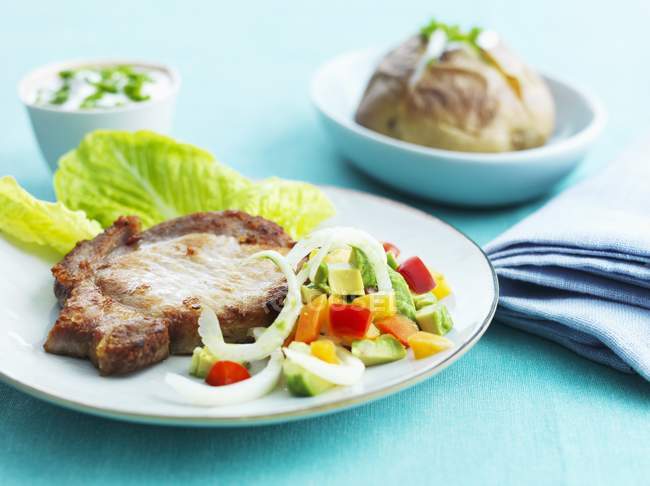 Pork chop served with salad — Stock Photo
