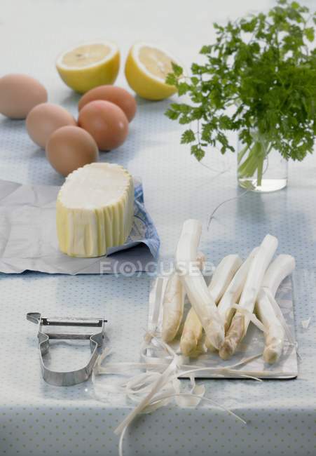 Espárragos e ingredientes para Salsa Holandesa sobre mesa con paño - foto de stock