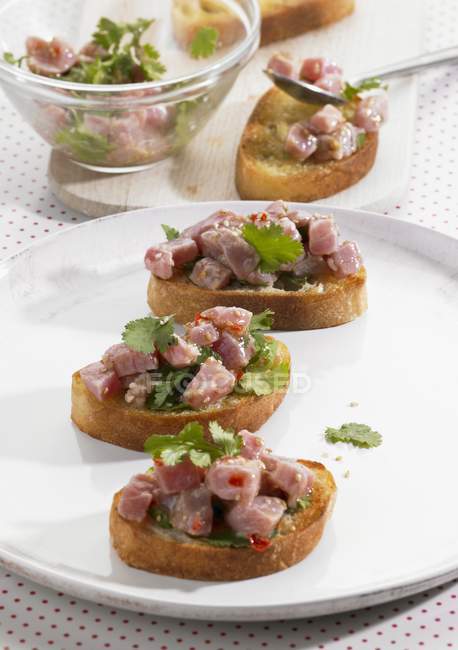 Elevated view of Crostini topped with raw tuna salad — Stock Photo