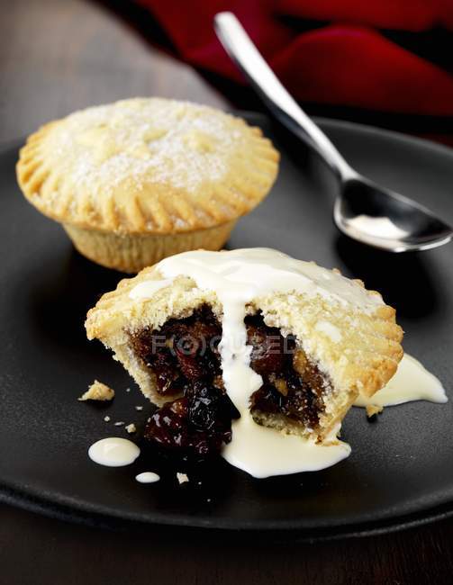 Closeup view of mince pie and cream on black plate — Stock Photo