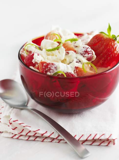 Vista da vicino del dessert Eton Mess con fragole e scorza di lime in ciotola rossa — Foto stock