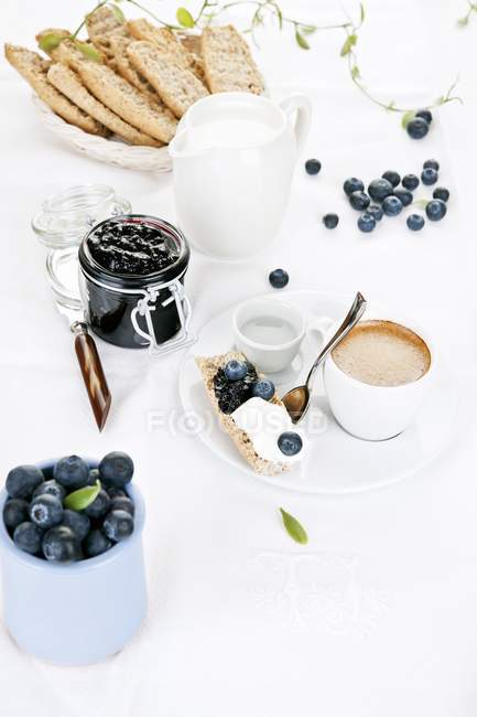 Closeup view of crisp rolls with blueberry jam, quark cream and espresso — Stock Photo