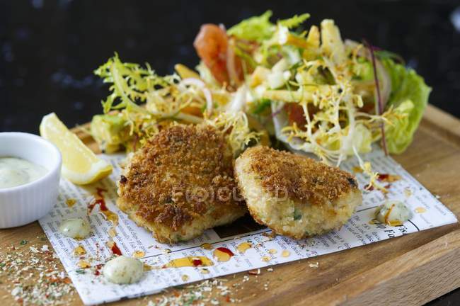 Gâteaux de saumon avec une salade de feuilles mélangées — Photo de stock