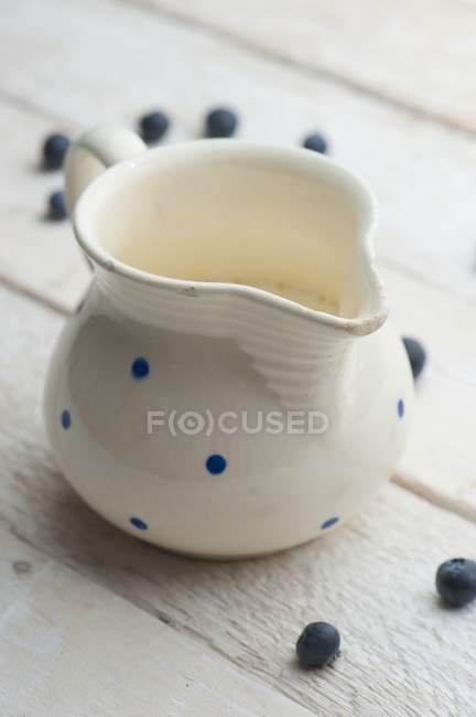 Jug of milk with blueberries — Stock Photo