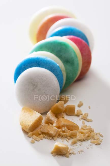 Haricots chocolatés colorés reposant sur une surface blanche — Photo de stock