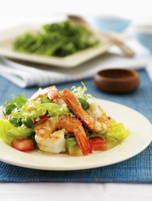 Prawn salad with asparagus and avocado on white plate over blue towel — Stock Photo