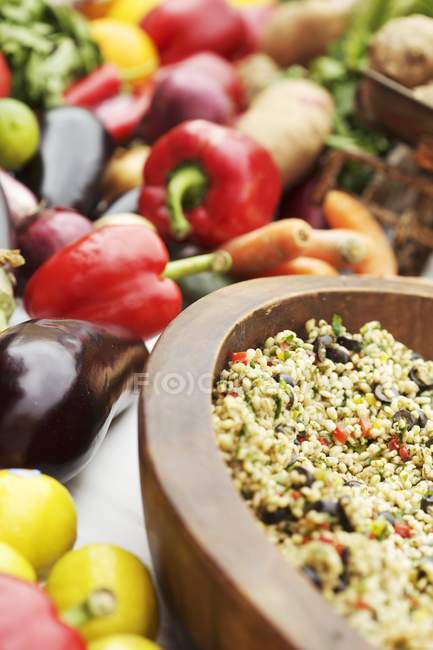 Свежие овощи и деревянная чаша с гречкой и овощами — стоковое фото