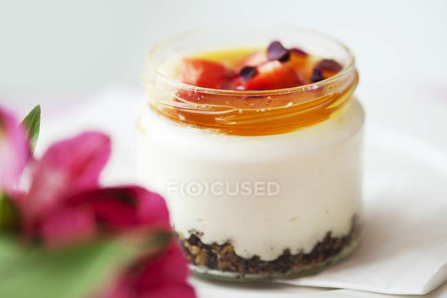 Closeup view of white chocolate cream with caramel and strawberries in screw top jar — Stock Photo