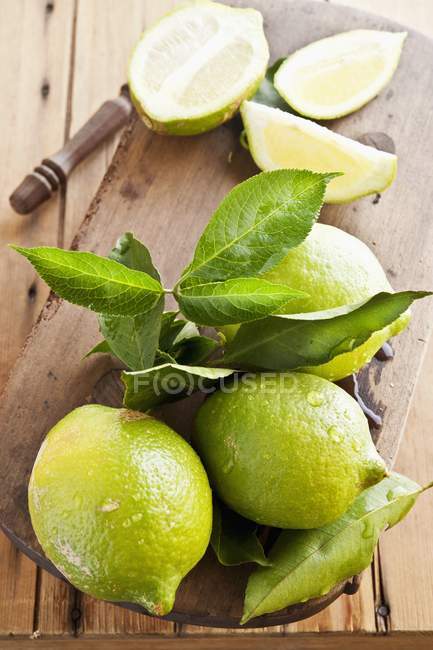Limoni verdi freschi con foglie — Foto stock